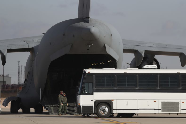 Un avión militar a la espera de que migrantes desciendan de un autobús para abordar el jueves 30 de enero de 2025, en Fort Bliss, en el paso, Texas, antes de ser deportados a Guatemala. (AP Foto/Christian Chávez, Archivo)