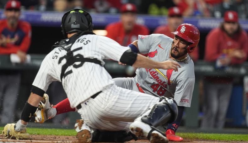 Iván Herrera, atrás, de los Cardenales de San Luis, se barre para llegar safe al plato y así anotar con un triple de Thomas Saggese, mientras el receptor de los Rockies de Colorado, Jacob Stallings, hace un toque tardío en la segunda entrada del juego de béisbol del miércoles 25 de septiembre de 2024, en Denver. (AP Foto/David Zalubowski)