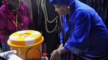 americateve | En esta foto del 26 de julio del 2014, la presidenta de Liberia Ellen Johnson Sirleaf, der., demuestra c&oacute;mo lavarse las manos adecuadamente para prevenir la propagaci&oacute;n del virus del &eacute;bola durante las celebraciones del D&iacute;a de l