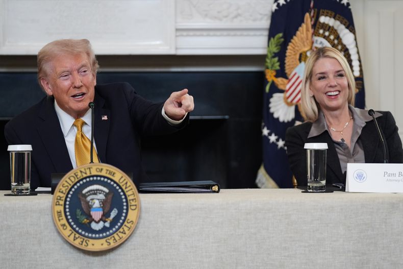 El presidente Donald Trump señala a un periodista para que le haga una pregunta durante una mesa redonda sobre cárteles delictivos en el Comedor de Estado de la Casa Blanca, el jueves 23 de octubre de 2025, en Washington, mientras la fiscal general Pam Bondi ríe. (AP Foto/Evan Vucci)