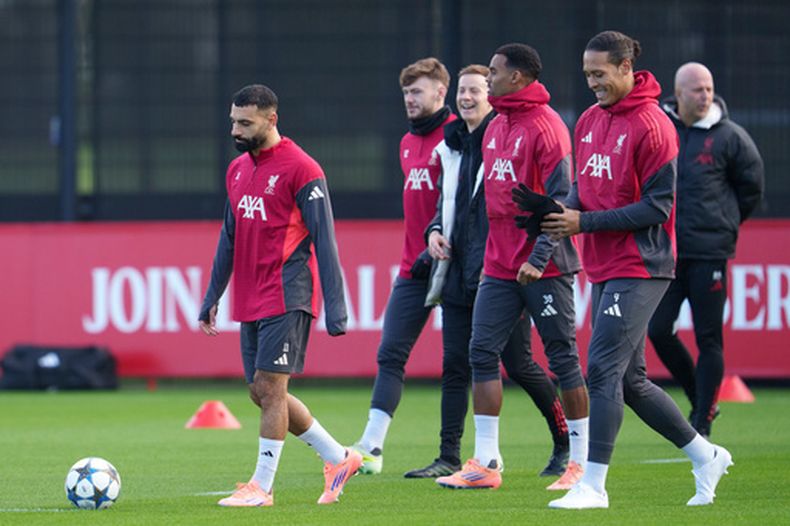 Mohamed Salah (izquierda) participa durante un entrenamiento de Liverpool, con el técnico Arne Slot a la derecha), el lunes 8 de diciembre de 2025, en Liverpool. (AP Foto/Jon Super)