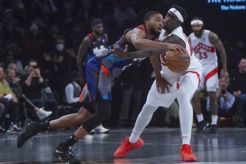 Mikal Bridges, izquierda, de los Nets de Brooklyn, maneja el balón ante Pascal Siakam, de los Raptors de Toronto, quien intenta robarlo, durante el partido de baloncesto del torneo In-Season de la NBA, el martes 28 de noviembre de 2023, en Nueva York. (AP Foto/Bebeto Matthews)