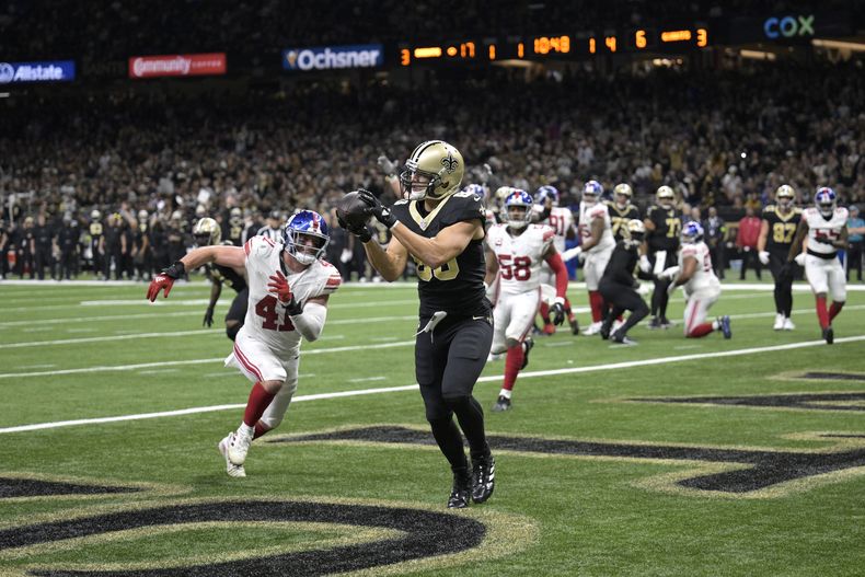 Jimmy Graham (80), tight end de los Saints de Nueva Orleans, atrapa un pase de anotación frente al linebacker Micah McFadden (41), de los Giants de Nueva York, durante la segunda mita del juego de la NFL del domingo 17 de diciembre de 2023, en Nueva Orleans. (AP Foto/Matthew Hinton)