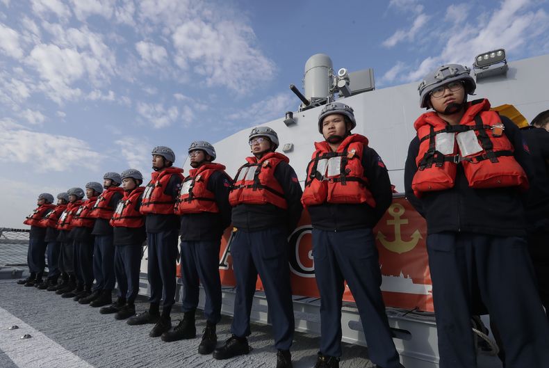 Tripulantes de la Armada taiwanesa se ven de pie junto a una patrullera de fabricación taiwanesa Tuo Chiang durante un simulacro de ataque en la ciudad de Kaohsiung, en el sur de Taiwán, el jueves 9 de enero de 2025. (AP Foto/Chiang Ying-ying)