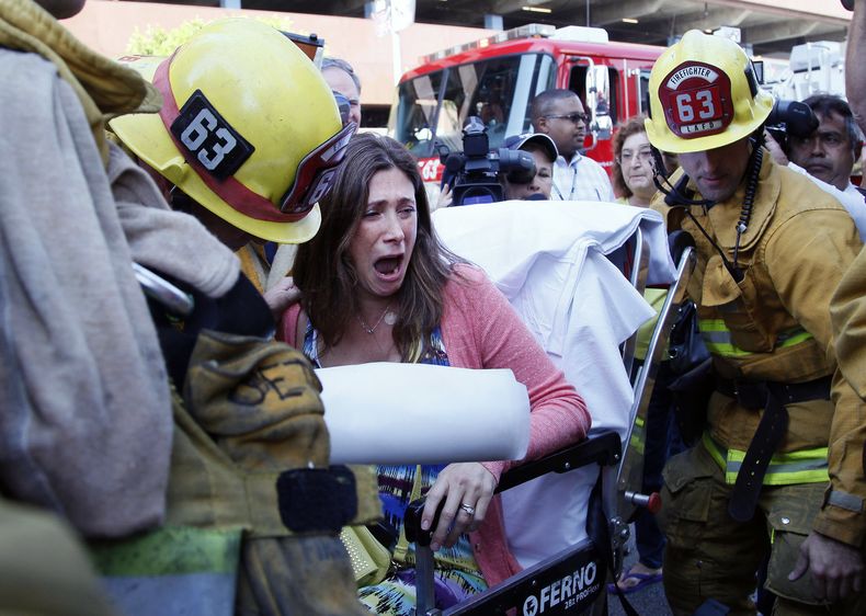 Avi Abril, que vive en un edificio alto de apartamentos que se incendi&oacute; es llevada a una ambulancia en Los Angeles, el viernes 18 de octubre de 2013. Ocho personas, incluido un ni&ntilde;o y tres bomberos, fueron hospitalizados debido al fuego, que