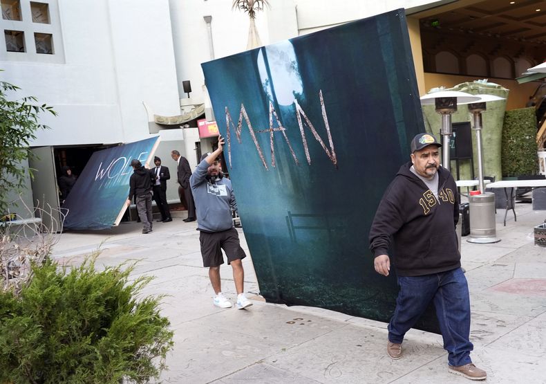 Trabajadores mueven mamparas de la nueva película Wolf Man después de que el estreno fuera cancelado debido a los fuertes vientos en la zona el martes 7 de enero de 2025 en el Teatro Chino TCL de Los Ángeles. (Foto AP/Chris Pizzello)