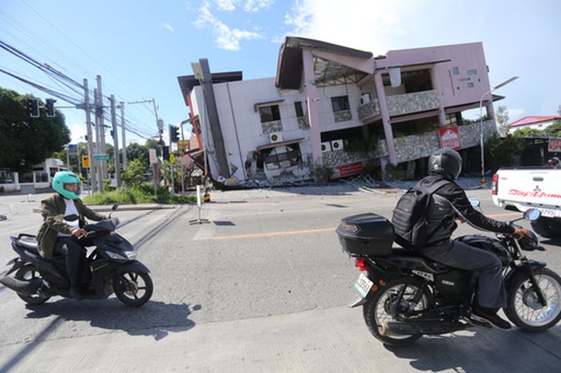 Dos personas en moto pasan por delante de un edificio caído tras un sismo en General Santos, Filipinas, el 8 de junio de 2026. (AP Foto)