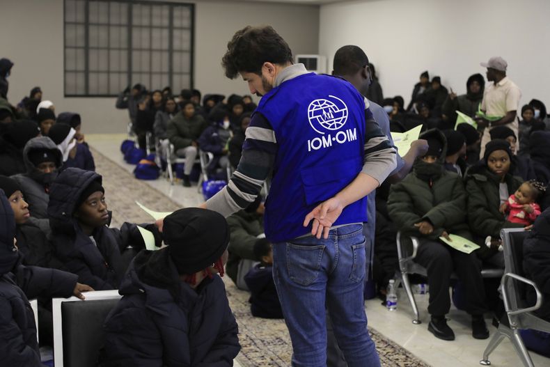 Un funcionario de la Organización Internacional de las Migraciones habla con migrantes nigerianos antes de ser deportados desde Trípoli, Libia, el 18 de marzo de 2025. (AP Foto/Yousef Murad)