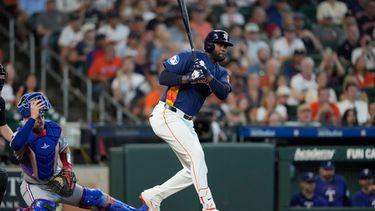 Yordan Alvarez, de los Astros de Houston (a la derecha), conecta un doblete impulsador de dos carreras mientras el receptor de los Rangers de Texas, Austin Wynns, observa durante la séptima entrada de un partido de béisbol el domingo 2 de agosto de 2026, en Houston. (Foto AP/David J. Phillip)