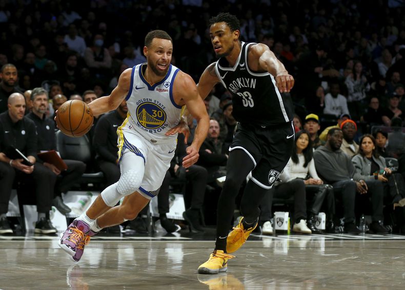 Stephen Curry (30), de los Warriors de Golden State, encara a Nic Claxton (33), de los Nets de Brooklyn, durante la primera mitad del juego de baloncesto de la NBA, el lunes 5 de febrero de 2024, en Nueva York. (AP Foto/John Munson)