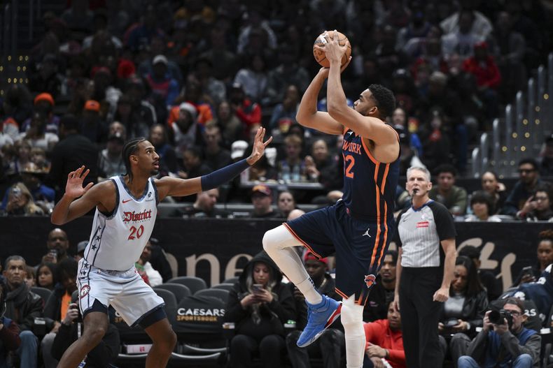 El pívot de los Knicks de Nueva York lanza el balón sobre el alero de los Wizards de Washhington Alexandre Sarr en el encuentro de la NBA del lunes 30 de diciembre del 2024. (AP Foto/Terrance Williams)
