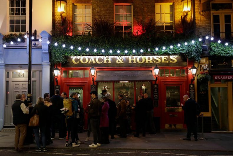 ARCHIVO – Un grupo de personas beben fuera del pub Coach & Horses el día de san Patricio, en el distrito de Covent Garden del centro de Londres, una popular área turística, el martes 17 de marzo de 2020. (AP Foto/Matt Dunham, Archivo)
