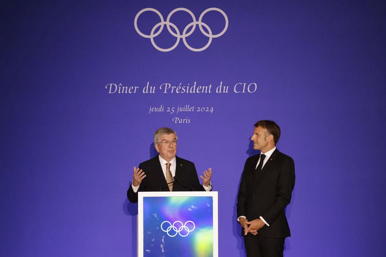 Thomas Bach (izquierda), presidente del Comité Olímpico Internacional, pronuncia un discurso junto a Emmanuel Macron, presidente de Francia, durante una cena en el Muso de Louvre, el jueves 25 de julio de 2024 (Ludovic Marin, Pool via AP)