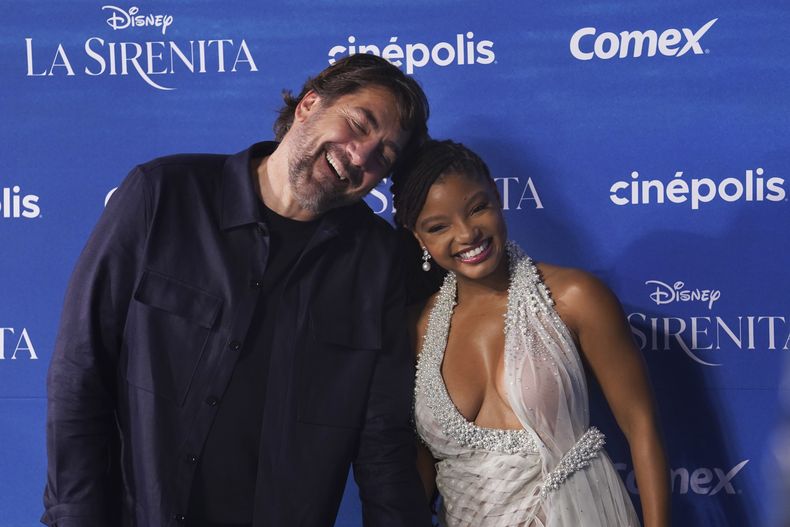Los actores Halle Bailey, derecha, y Javier Bardem posan en la alfombra azul de la película La Sirenita en la Ciudad de México el 11 de mayo de 2023. (Foto AP/Marco Ugarte)