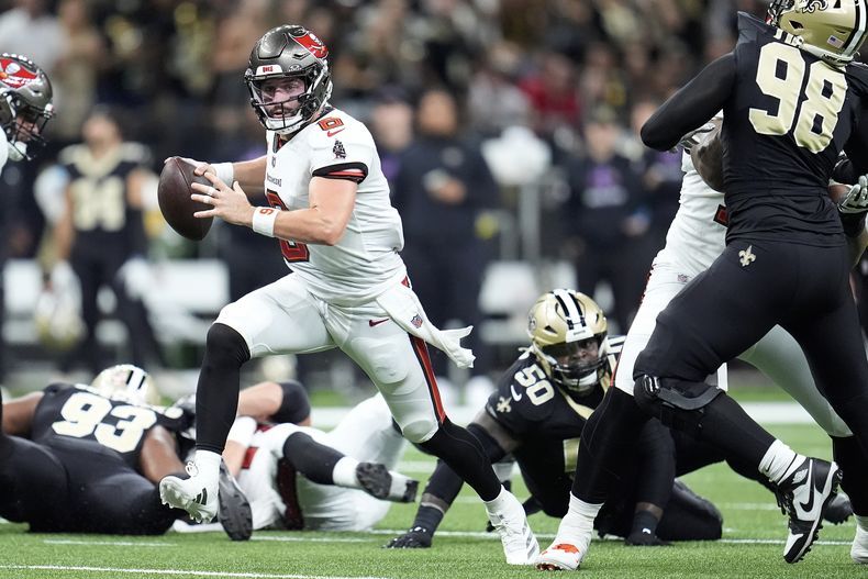 Baker Mayfield, centro, quarterback de los Buccaneers de Tampa Bay, corre con el balón en el partido contra los Saints de Nueva Orleans durante la primera mitad de la primera mitad del partido de la NFL del domingo 13 de octubre de 2024, en Nueva Orleans. (AP Foto/Michael Conroy)