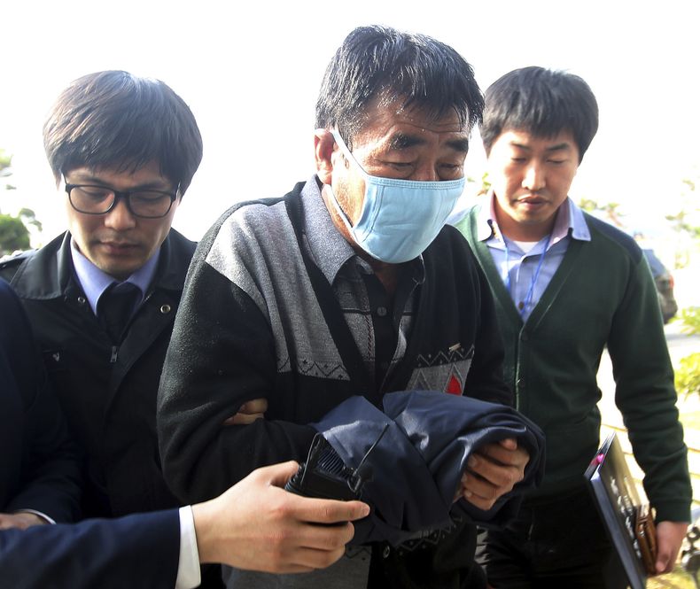 Lee Joon-seok (centro), capit&aacute;n del ferri que se hundi&oacute; en la costa de Corea del Sur, a su llegada a los cuarteles de la polic&iacute;a en Mokpo, al sur de Se&uacute;l, el 19 de abril de 2013. (Foto de AP/Yonhap, archivo) Prohibido su uso en