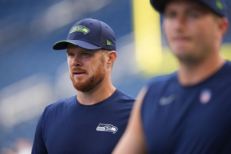 El QB de los Seahawks de Seattle, Sam Darnold (izquierda), camina por el campo durante el calentamiento previo a un partido de la NFL contra los Patriots de Nueva Inglaterra el miércoles 9 de septiembre de 2026, en Seattle. (Foto AP/Lindsey Wasson)