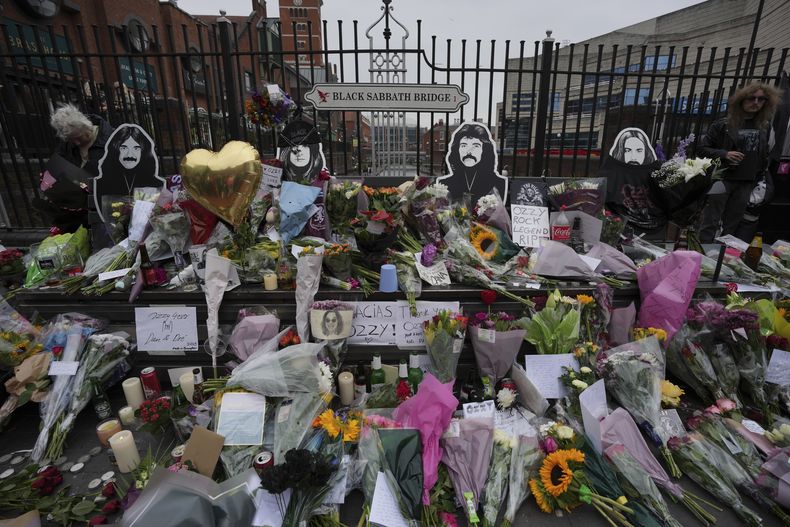 Fans dejan flores para conmemorar la muerte de Ozzy Osbourne en el puente Black Sabbath en Birmingham, el miércoles 23 de julio de 2025.(Foto AP/Kin Cheung)