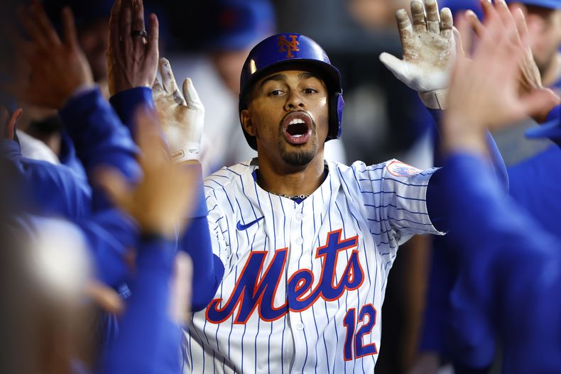 El puertorriqueño Francisco Lindor, de los Mets de Nueva York, recibe felicitaciones en la cueva luego de batear un jonrón ante los Diamondbacks de Arizona, el jueves 30 de mayo de 2024 (AP Foto/Noah K. Murray)