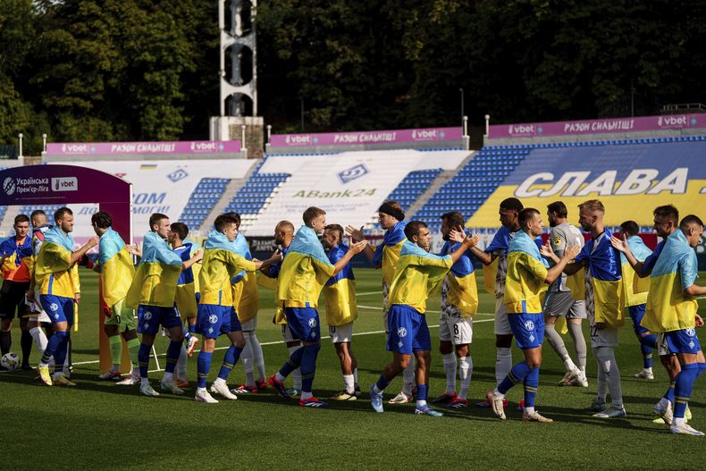 Los futbolistas del Dinamo de Kiev y el Zorya Luhansk se saludan antes del partido de la Liga Premier de Ucrania en Kiev, Ucrania, el sábado 14 de septiembre de 2024. (AP Foto/Evgeniy Maloletka)