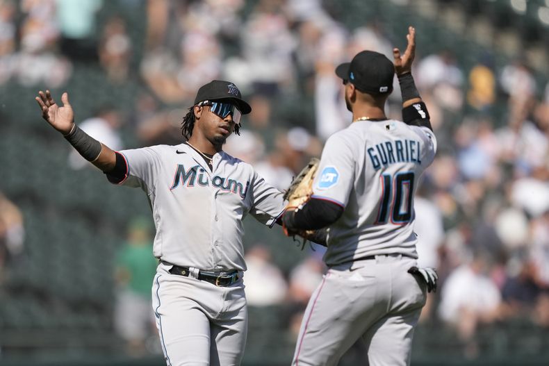 El dominicano Jean Segura y su compañero de los Marlins de Miami, el cubano Yulieski Gurriel, celebran el triunfo de su equipo 5-1 sobre los Medias Blancas de Chicago, el sábado 10 de junio de 2023, en Chicago. (AP Foto/Charles Rex Arbogast)