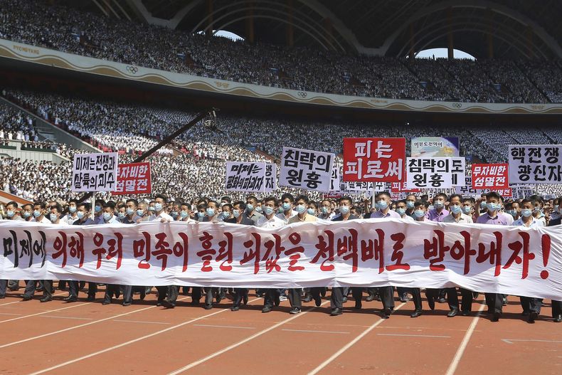 Gente de Pyongyang participa en una manifestación tras una marcha para conmemorar lo que Corea del Norte conoce como el día de lucha contra el imperialismo estadounidense en el Estadio del Primero de Mayo en Pyongyang, Corea del Norte, el domingo 25 de junio de 2023. El cartel dice ¡Hagamos que los imperialistas estadounidenses paguen duramente por la sangre derramada por la nación coreana!, Estados Unidos es el jefe de la guerra y la masacre, aniquilación inmisericorde, Estados Unidos es el destructor de la paz, jefe de agresión, sangre por sangre y maniaco de guerra nuclear. (AP Foto/Jon Chol Jin)