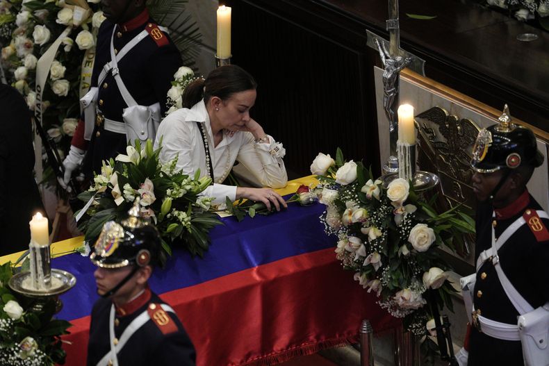 ARCHIVO - Claudia Tarazona se apoya sobre el ataúd de su marido, el precandidato presidencial Miguel Uribe, que murió de los disparos recibidos en un mitin político, en Bogotá, Colombia, el 12 de agosto de 2025. (AP Foto/Iván Valencia, Archivo)