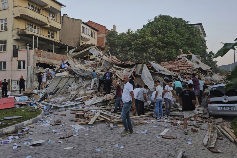 Personas retiran los escombros de un edificio derrumbado tras un terremoto en Sindirgi, noroeste de Turquía, el domingo 10 de agosto de 2025. (Bahadir Demirceviren/IHA vía AP)