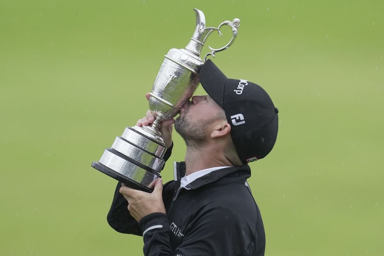 Brian Harman besa el trofeo de campeón del Abierto Británico de golf, el domingo 23 de julio de 2023, en Hoylake, Inglaterra. (AP Foto/Kin Cheung)