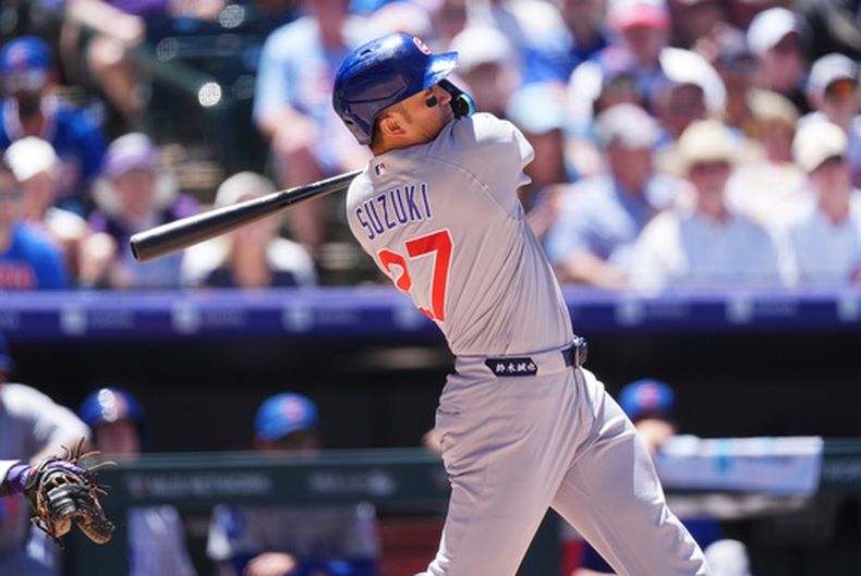 Seiya Suzuki, de los Cachorros de Chicago, sigue la trayectoria de su grand slam ante el lanzador abridor de los Rockies de Colorado, Ryan Feltner, en la cuarta entrada de un partido de béisbol el jueves 11 de junio de 2026, en Denver. (Foto AP/David Zalubowski)