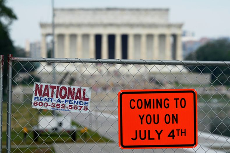 Se observan letreros colocados en una cerca de malla metálica alrededor del estanque reflectante del Monumento a Lincoln, el viernes 26 de junio de 2026, en Washington. (Foto AP/Carolyn Kaster)