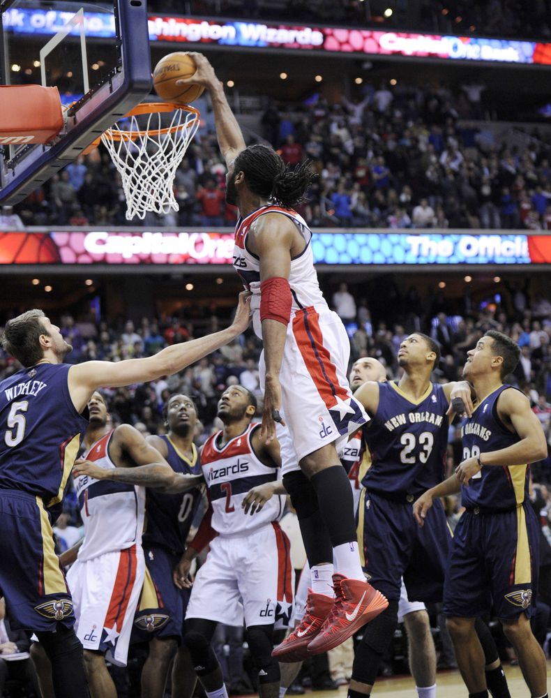 El brasile&ntilde;o Nen&eacute; Hilario, centro, de los Wizards de Washington, clava el bal&oacute;n ante Jeff Withey (5), Anthony Davis (23), Al-Farouq Aminu (0) y Brian Roberts (22), de los Pelicans de Nueva Orle&aacute;ns, en los &uacute;ltimos segundo