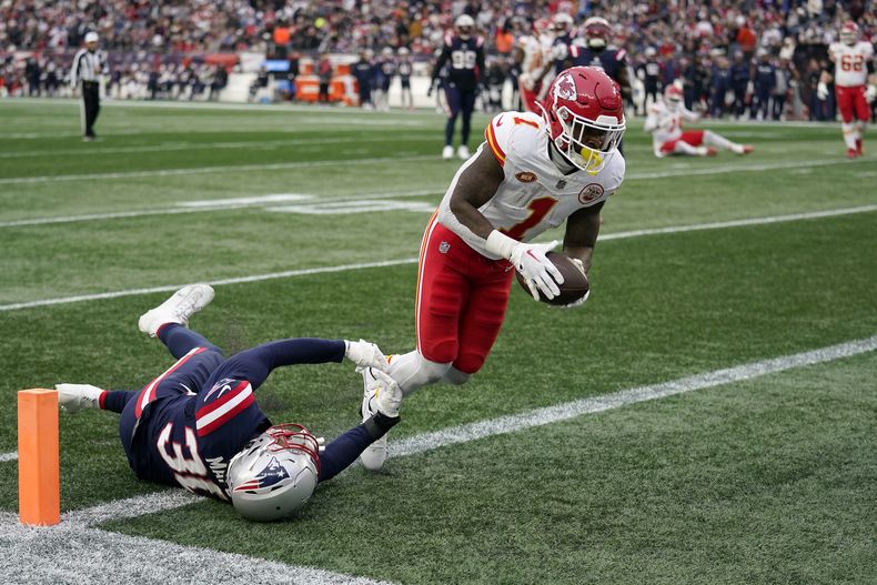 Jerick McKinnon (1), running back de los Chiefs de Kansas City, entra a la zona de anotación para un touchdown mientras el linebacker de los Patriots de Nueva Inglaterra Marte Mapu (30) intenta detenerlo, el domingo 17 de diciembre de 2023, en Foxborough, Massachusets. (AP Foto/Charles Krupa)
