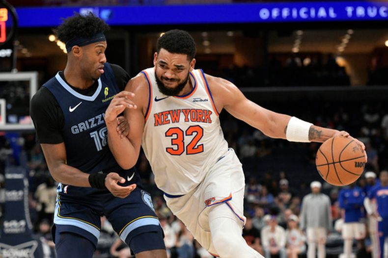 El dominicano Karl-Anthony Towns, de los Knicks de Nueva York, conduce el balón frente a Olivier-Maxence Prosper, de los Grizzlies de Memphis, en el duelo del miércoles 1 de abril de 2026 (AP Foto/Brandon Dill)