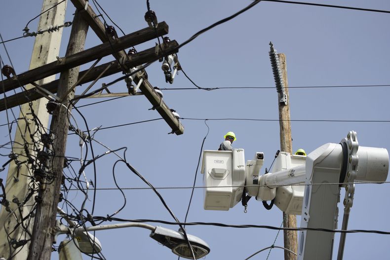 ARCHIVO - Una brigada de la Autoridad de Energía Eléctrica repara líneas de distribución dañadas por el huracán María, el 19 de octubre de 2017, en la comunidad Cantera de San Juan, Puerto Rico. (AP Foto/Carlos Giusti, Archivo)