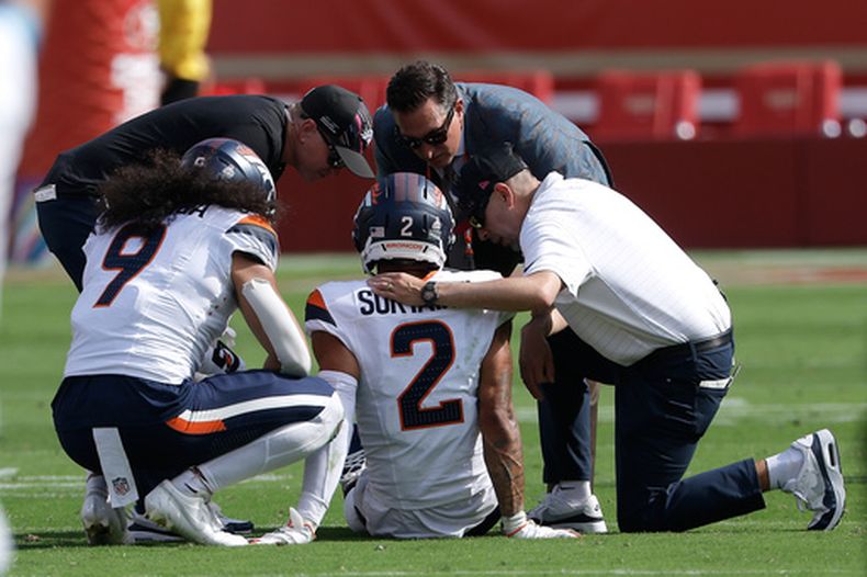 El esquinero de los Broncos de Denver, Pat Surtain II (2), recibe atención médica durante la primera mitad de un partido de fútbol americano de la NFL contra los 49ers de San Francisco en Santa Clara, California, el 4 de octubre de 2026. (Foto AP/Kelley L. Cox)