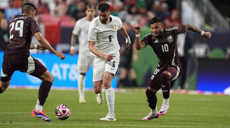 El volante uruguayo Rodrigo Bentancur (centra) esquiva a los mexicanos Guillermo Martínez (izquierda) y Alexis Vega durante un partido amistoso, el miércoles 5 de junio de 2024, en Denver. (AP Foto/David Zalubowski)