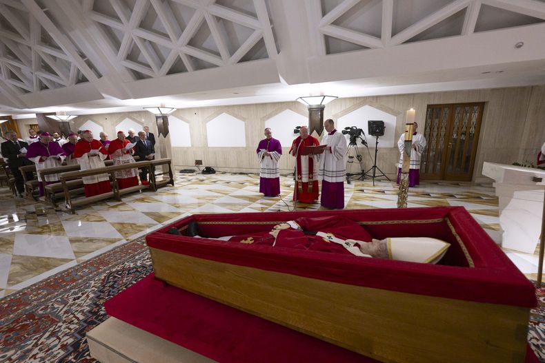 El cuerpo del papa Francisco yace en su capilla privada en el Vaticano,el lunes 21 de abril de 2025. En primera línea, desde la izquierda, el secretario de Estado del Vaticano, Pietro Parolin, el decano y cardenal Giovanni Battista Re; una persona no identificada; el maestro de ceremonias y arzobispo Diego Giovanni Ravelli; el cardenal y camarlengo, Kevin Joseph Farrell, y el maestro de ceremonias Lubomir Welnitz. (Vatican Media via AP, HO)