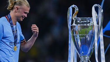 Erling Haaland del Manchester City sonríe al pasar frente al trofeo de la Liga de Campeones tras la victoria 1-0 ante el Inter de Milán en la final, el domingo 11 de junio de 2023, en Estambul. (AP Foto/Manu Fernández)