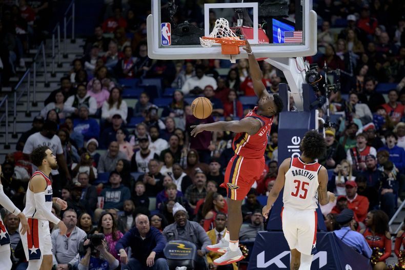 Zion Williamson, alero de los Pelicans de Nueva Orleáns, realiza una clavada frente al alero Marvin Bagley III en el partido del miércoles 14 de febrero de 2024 (AP Foto/Matthew Hinton)