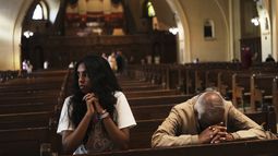 Thurvi Valli y su abuelo, Sitham Valli, rezan dentro de la Iglesia de la Cripta en el santuario de Saint Joseph Mount Royal, en Montreal, el sábado 28 de junio de 2025. (AP Foto/Luis Andrés Henao)