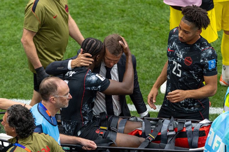 El técnico de Canadá, Jesse Marsch, abraza a Ismael Koné (8) mientras sale retirado en camilla luego de sufrir una lesión durante el partido ante Qatar por el Grupo B del Mundial, el jueves 18 de junio de 2026, en Vancouver. (Timothy Matwey/The Canadian Press via AP)
