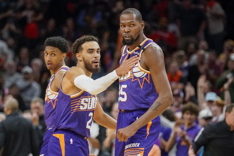 Kevin Durant (derecha) de los Suns de Phoenix, reta a los Mavericks de Dallas, mientras su compañero Tyus Jones lo detiene, el sábado 26 de octubre de 2024 (AP Foto/Darryl Webb)