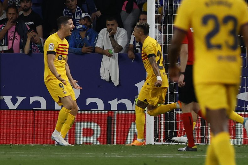 Robert Lewandowski (izquierda) celebra tras anotar el tercer gol del Barcelona en el partido contra el Espanyol en la Liga española, el domingo 14 de mayo de 2023. (AP Foto/Joan Monfort)