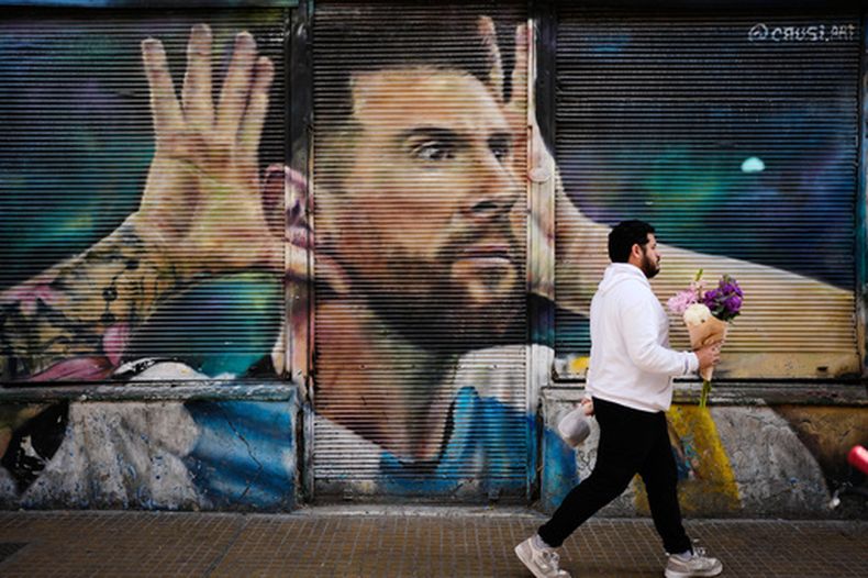 Un individuo camina frente a un mural con la imagen del futbolista argentino Lionel Messi, el lunes 31 de agosto de 2026, en Buenos Aires. (AP Foto/Natacha Pisarenko)