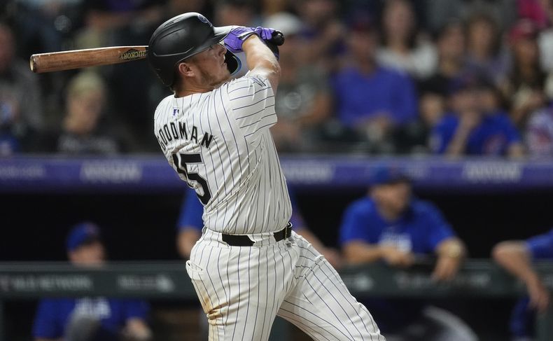 Hunter Goodman, de los Rockies de Colorado, sigue el vuelo de la pelota en el grand slam ante el relevista de los Cachorros de Chicago Nate Pearson en la octava entrada del juego de béisbol, el viernes 13 de septiembre de 2024, en Denver. (AP Foto/David Zalubowski)