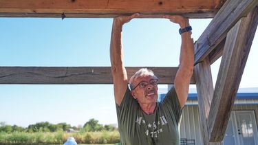 Ed Westrick, de 59 años, trabaja en el tejado de un edificio pequeño en su vivienda en una zona rural cerca de Commerce, Texas, el viernes 18 de septiembre de 2026. (AP Foto/LM Otero)