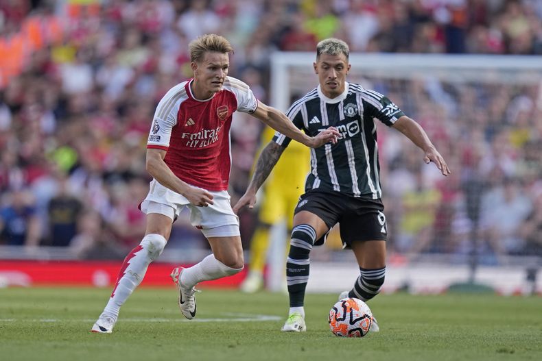 Martin Odegaard (izquierda) de Arsenal y Lisandro Martínez del Manchester United en el partido de la Liga Premier, el domingo 3 de septiembre de 2023, en Londres. (AP Foto/Kirsty Wigglesworth)