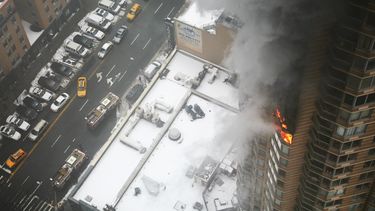 americateve | Llamas y humo salen por una ventana del piso 20 en un edificio de departamentos cerca de Times Square, el domingo 5 de enero del 2014 en Nueva York. Las autoridades dijeron que una persona muri&oacute; y otra result&oacute; herida de gravedad en un incend