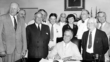 ARCHIVO – El presidente Franklin Roosevelt firma la Ley de Seguridad Social en Washington, el 14 de agosto de 1935. (AP Foto, Archivo)